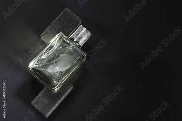 Fototapeta Stylish presentation of luxury men`s perfume in bottle on black background, top view. Space for text