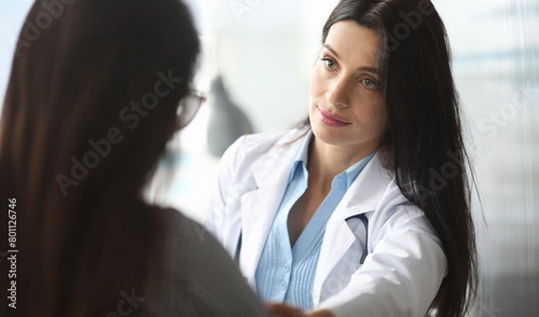 Fototapeta Adult caucasian doctor is sympathetic to patient. Psychological support for seriously ill people concept