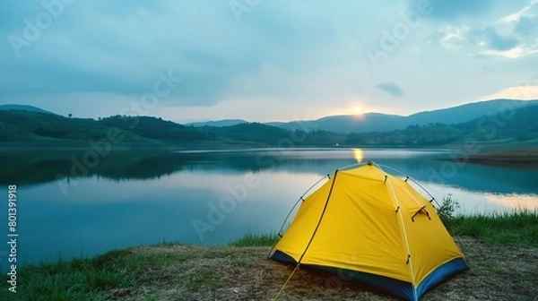 Fototapeta Tent by the lake in a beautiful landscape, evening time. Camping scene with tent on beautiful mountains and lake. 
Golden sunrise illuminating tent camping dramatic mountain landscape.