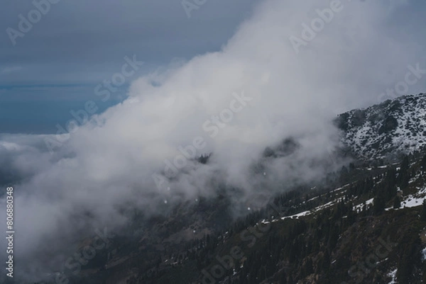 Obraz Clouds over snowy mountain peaks, beautiful landscape