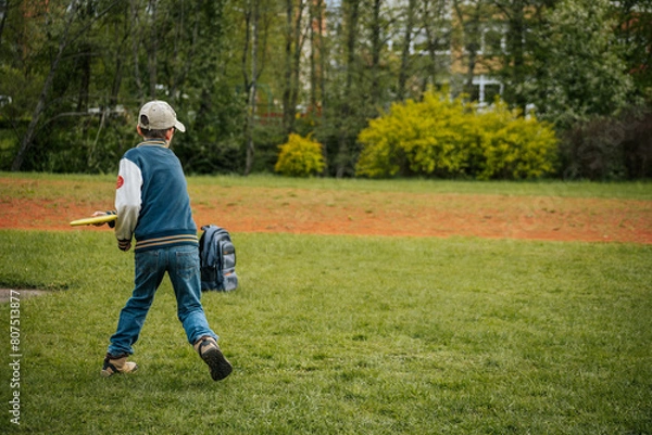 Fototapeta A boy throws disc golf. A young boy learns to throw a discus