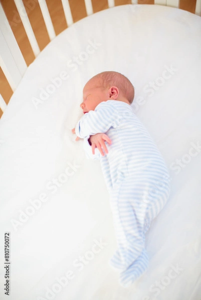 Fototapeta Little baby on white bed