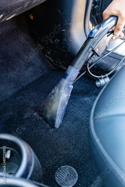 Fototapeta wash worker washes a car, vacuums the interior of the car. Dry cleaning and car detailing. Washing vacuum cleaner. Car interior care.