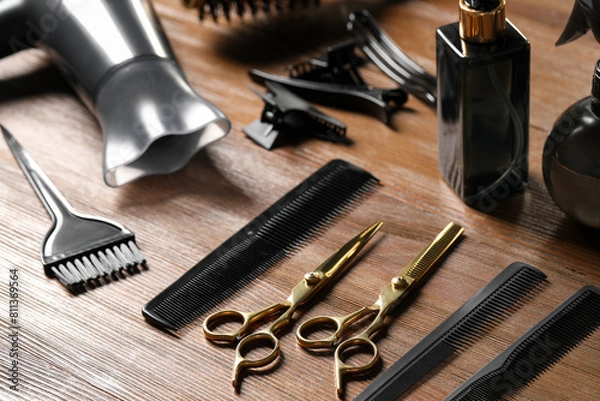 Fototapeta Hairdresser tools. Different scissors and combs on wooden table, closeup