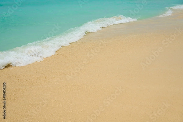 Fototapeta Waves and foam on a tropical sandy beach.