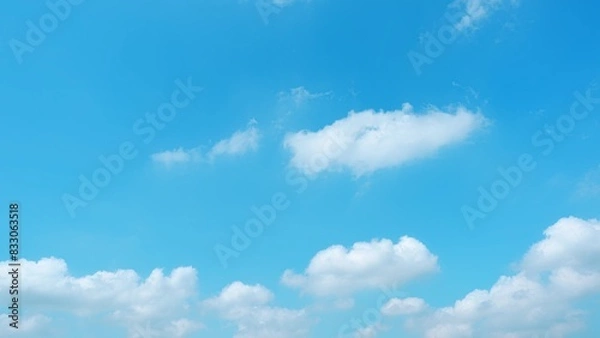 Fototapeta A vibrant blue sky dotted with fluffy, white clouds. The clouds are scattered across the sky, creating a serene and picturesque scene, evoking a sense of calm and tranquility. Horizon background. 
