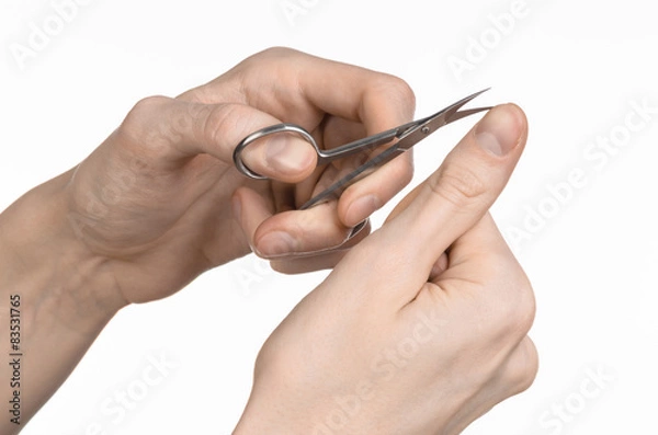 Fototapeta Hand holding scissors for manicure isolated on white background