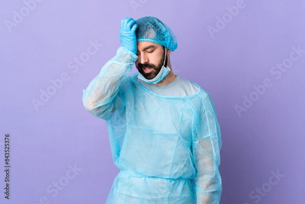 Fototapeta Surgeon man with beard with blue uniform over isolated purple background with headache