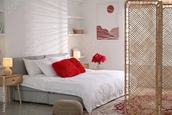 Fototapeta Beautiful folding screen, nightstand and large bed in bedroom. Interior design