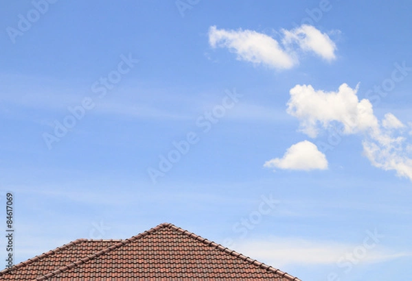 Fototapeta House brown brick roof, blue sky and cloud background.