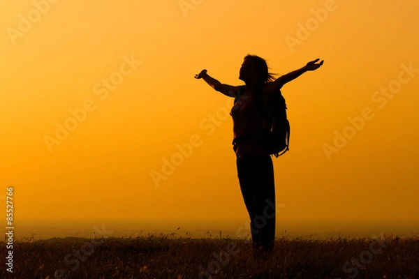 Fototapeta Woman hiker greeting the sunset