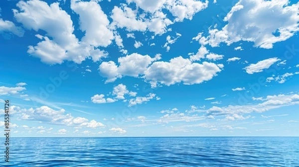 Fototapeta Calm ocean beneath a bright blue sky with scattered clouds