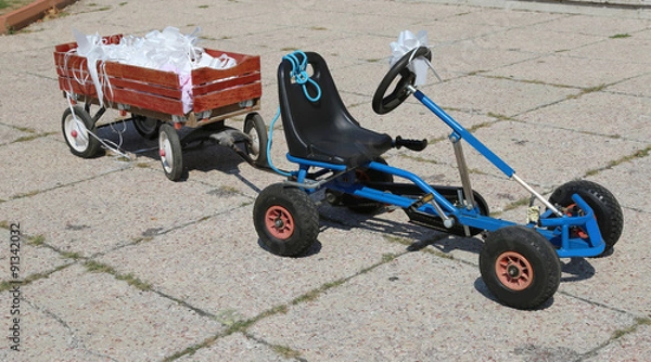 Fototapeta pedal go-kart with a cart with flakes stuck to the bride and gro