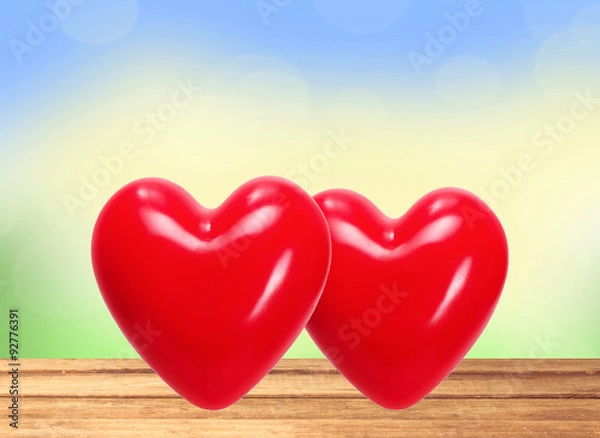 Fototapeta Red hearts on wooden table over nature background