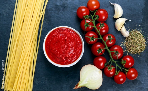 Fototapeta Ingredients for Spaghetti with marinara sauce.  Ready to Cook. On blue background