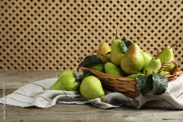 Fototapeta Fresh green pears and leaves with water drops on wooden table. Space for text