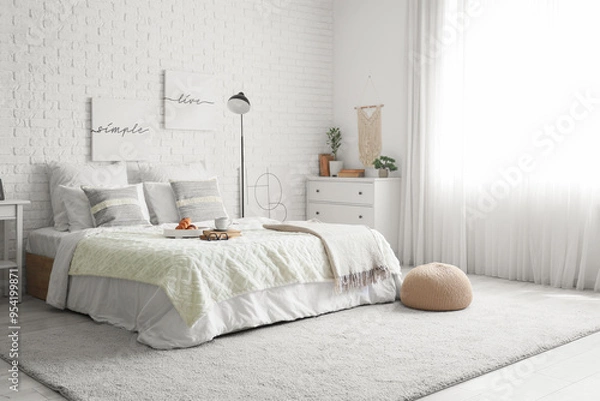 Fototapeta Interior of light bedroom with lamp, breakfast and books on bed