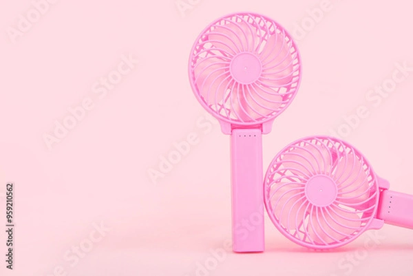 Fototapeta Mini electric fans on pink background, closeup