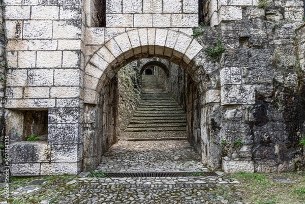 Fototapeta Archway leading into Strada del Soccorso in Brescia castle with detailed stone textures. The composition highlights the depth of the staircase and arch