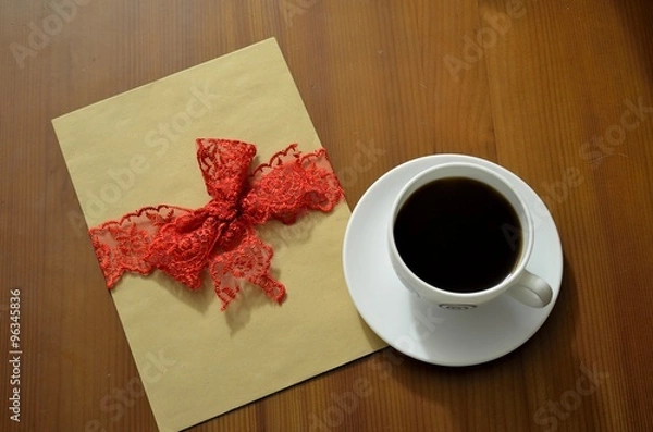 Fototapeta close up of a coffee cup and a blank card on a table