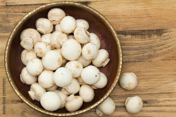 Fototapeta mushrooms in bowl on brown wooden background