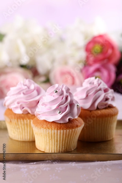 Fototapeta Tasty cupcakes on bright background