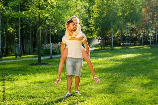 Fototapeta Guy playing with a girl in the park. 