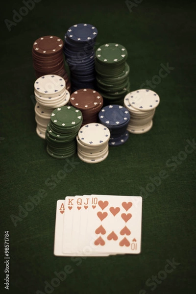 Fototapeta Cards and stack of poker chips and on a green background 