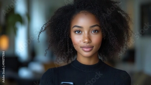 Fototapeta elegant portrait of a confident young black woman holding a smartphone crisp white background highlights her natural beauty and modern style in a professional headshot