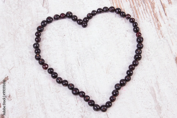 Fototapeta Heart of fresh elderberry on old wooden background, symbol of love